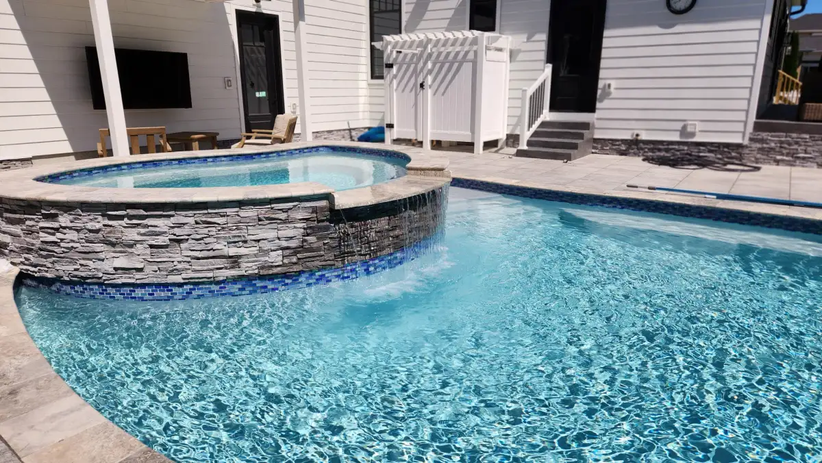 Custom pool with stone patio and landscaping in Sussex County Delaware